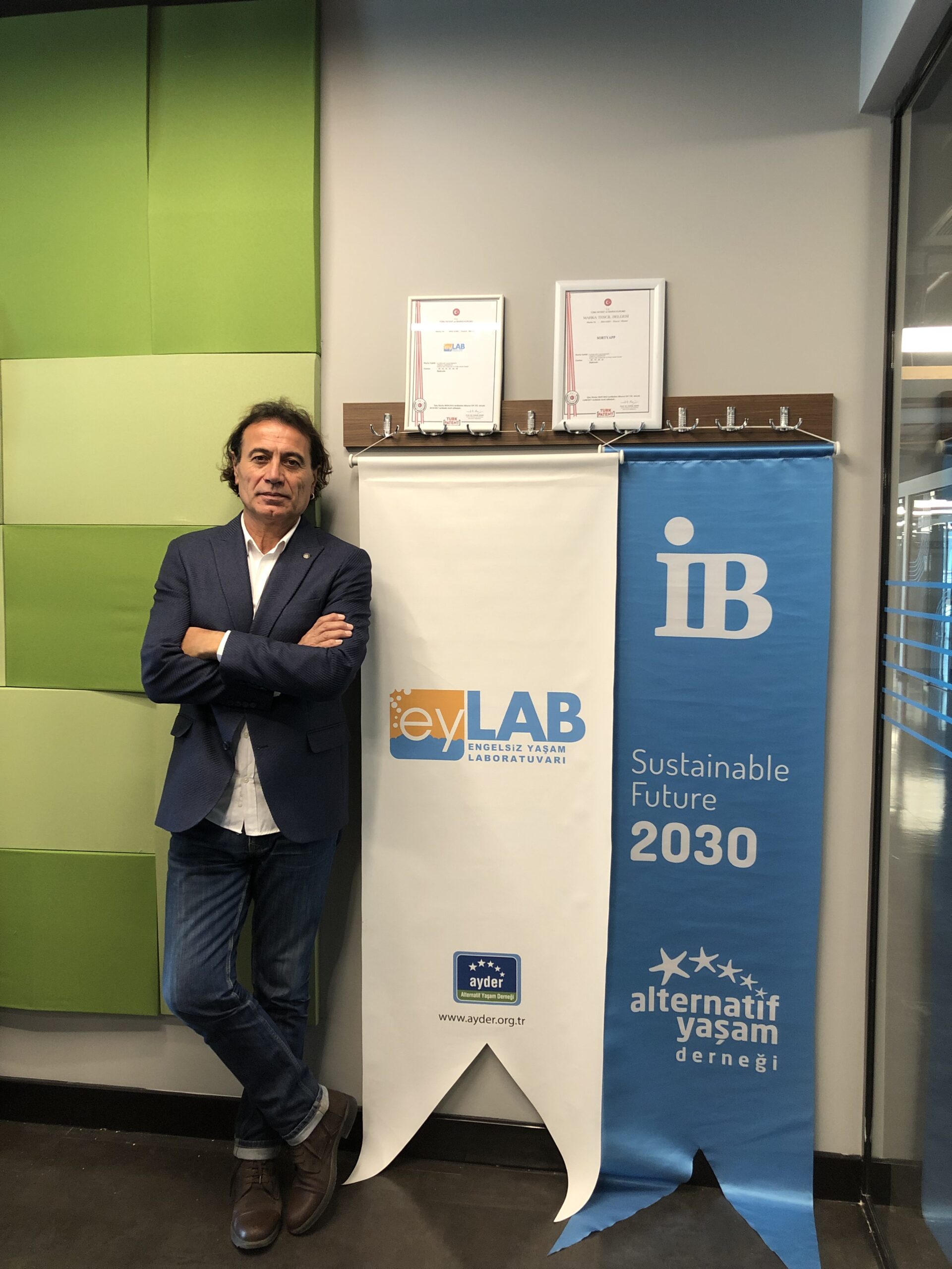 Alternatif Yaşam Derneği kurucusu Ercan Tutal, eyLAB ve 2030 Sürdürülebilir Gelecek projesi görseli önünde